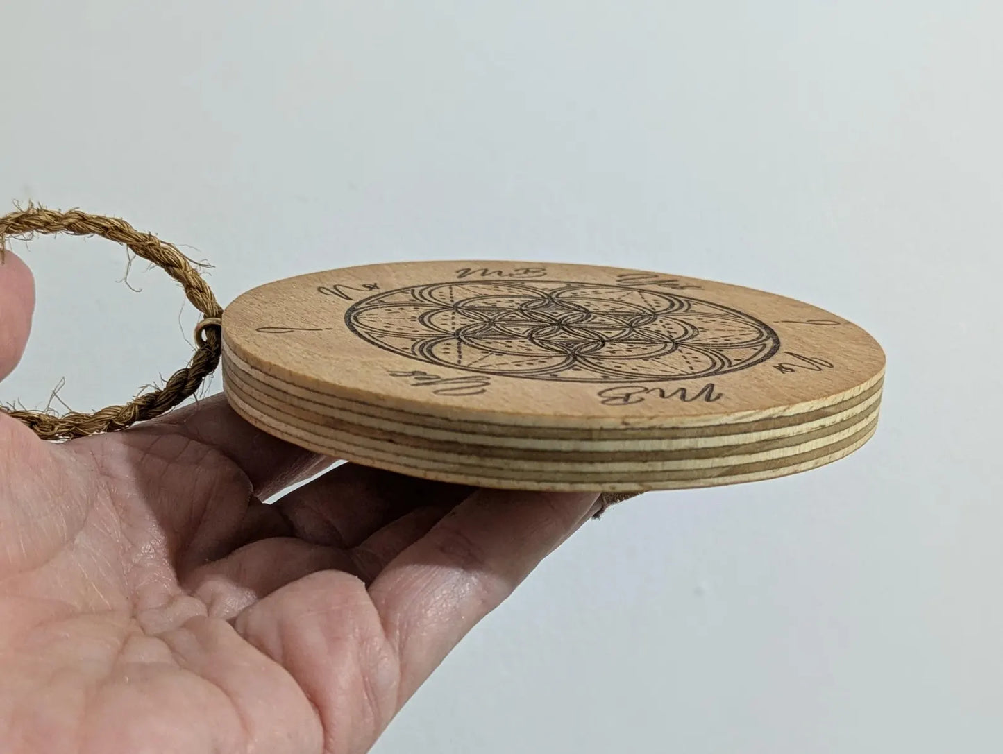 Recycled ply wood pendulum dowsing board with geometric design.