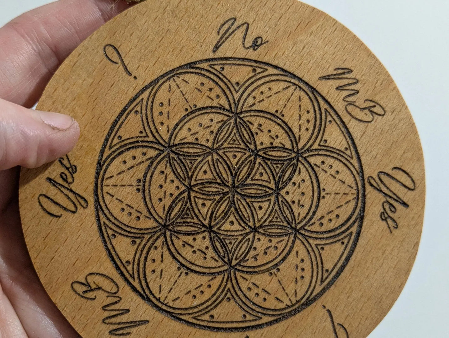 Recycled ply wood pendulum dowsing board with geometric design.