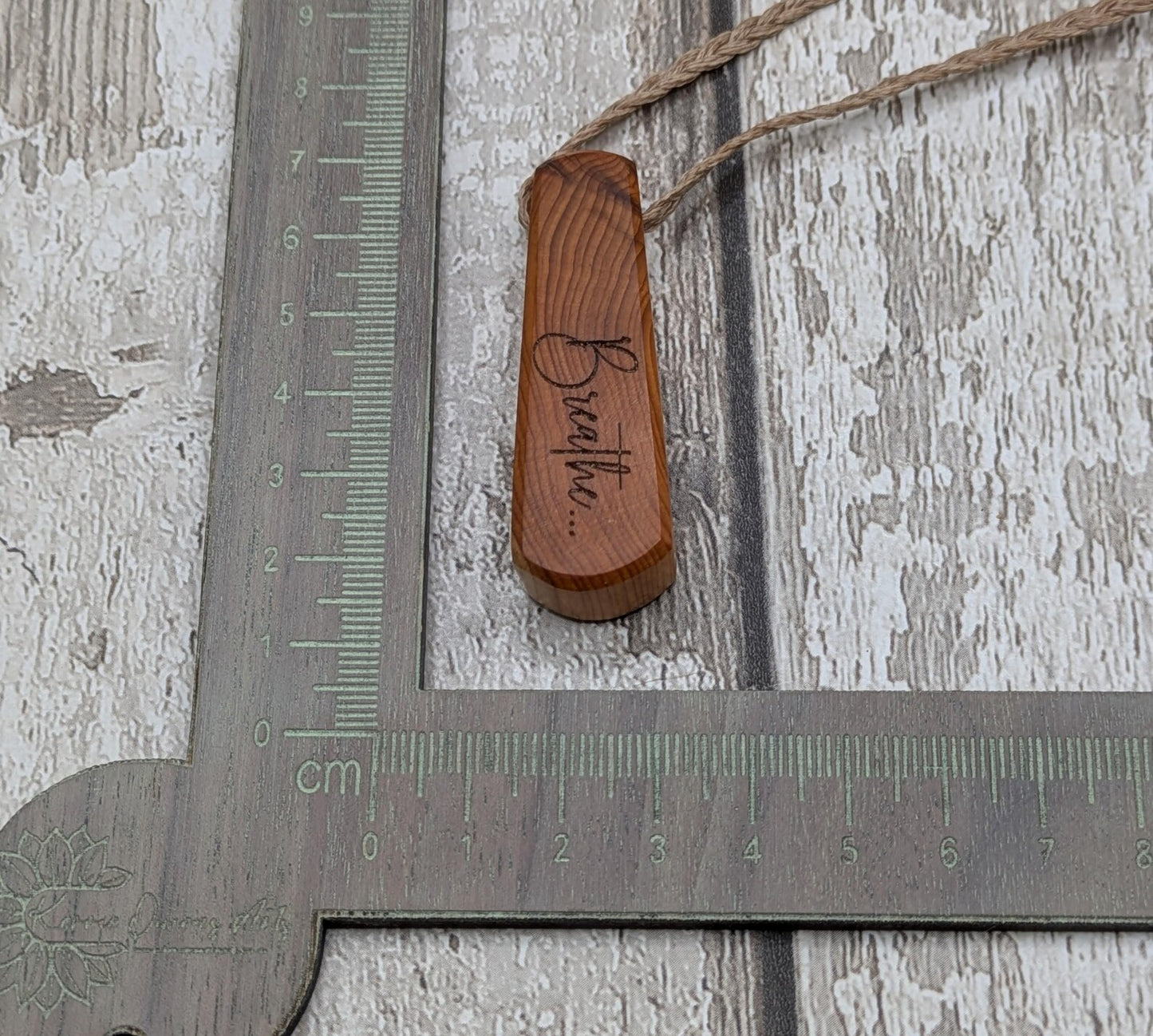Yew wood laser engraved breathe tear drop pendant.