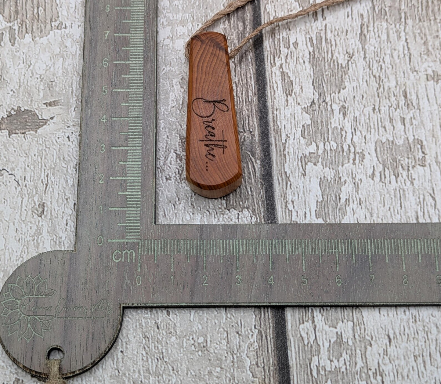 Yew wood laser engraved breathe tear drop pendant.