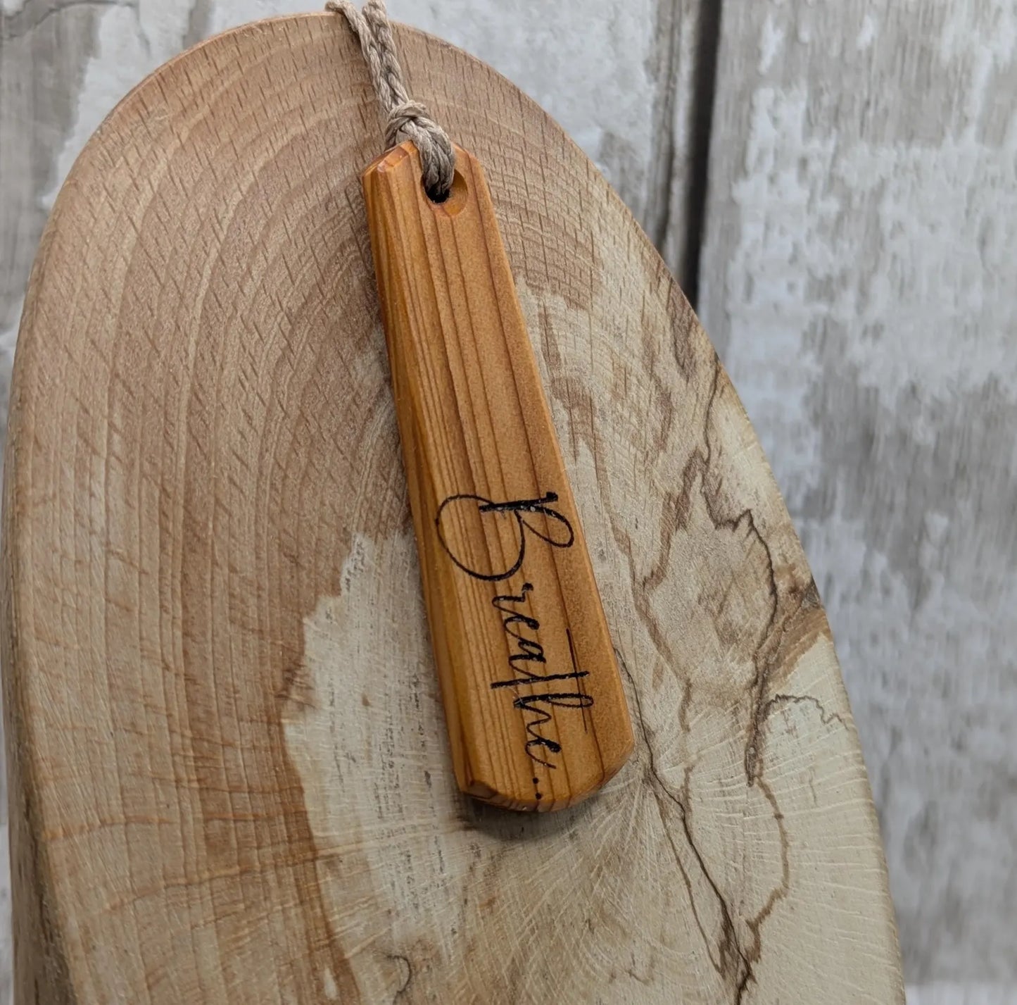Yew wood roimata drop pendant with breathe mantra laser print.