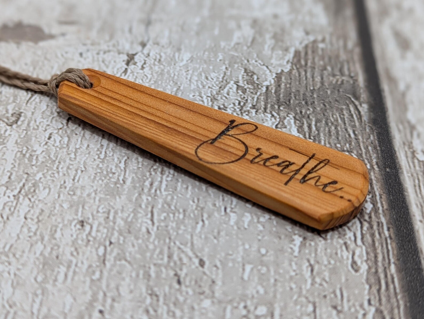 Yew wood roimata drop pendant with breathe mantra laser print.