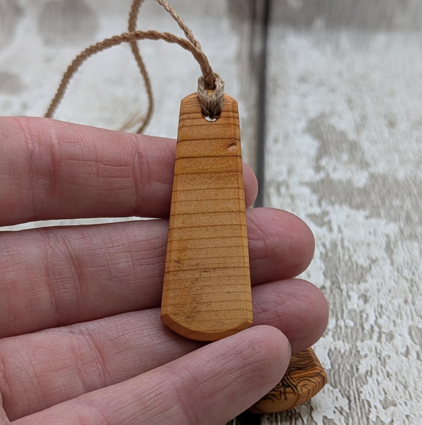 One Yew wood ammonite laser printed tear drop pendant.