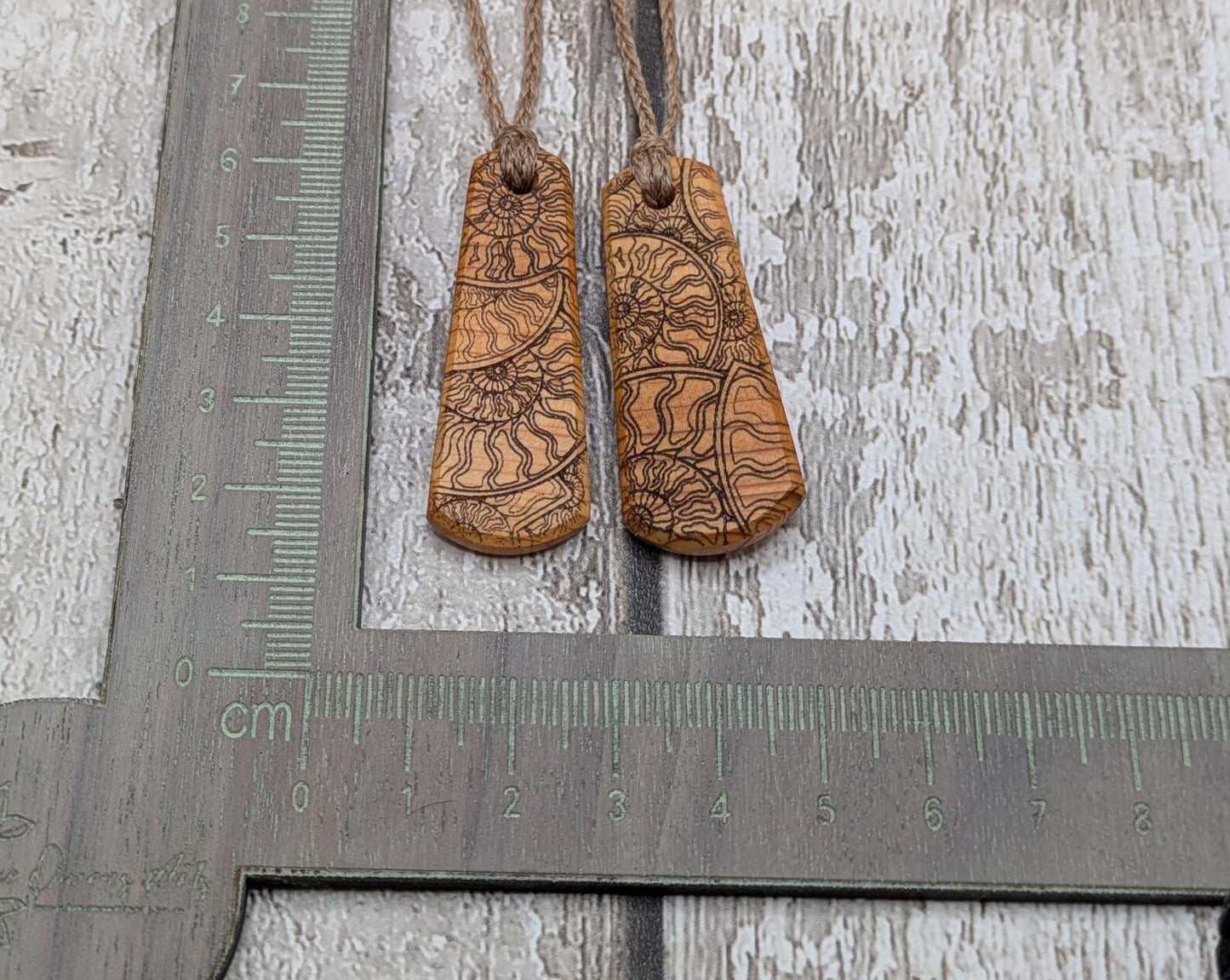 One Yew wood ammonite laser printed tear drop pendant.
