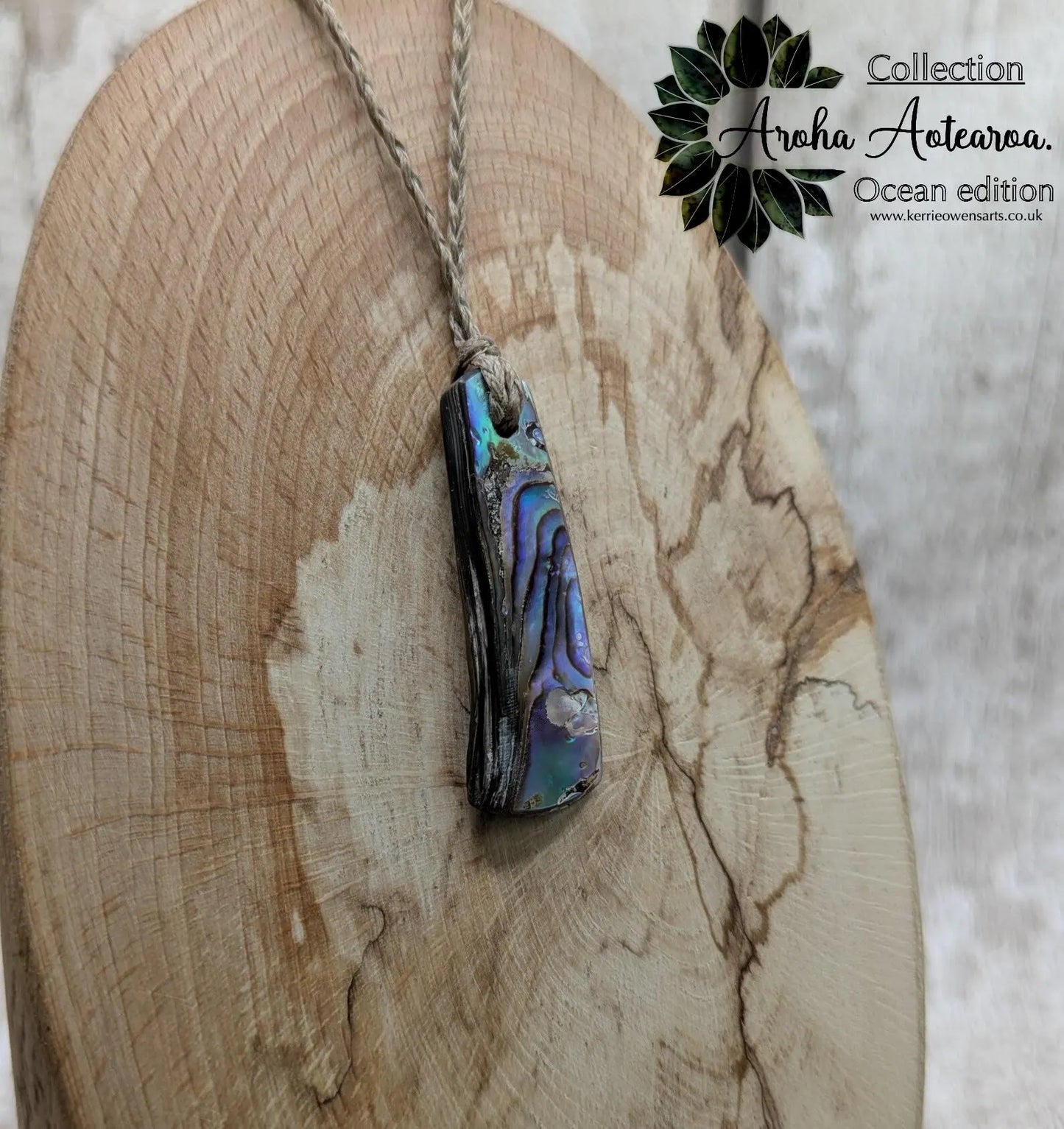 New Zealand rainbow pāua shell pendant on a churn chain.