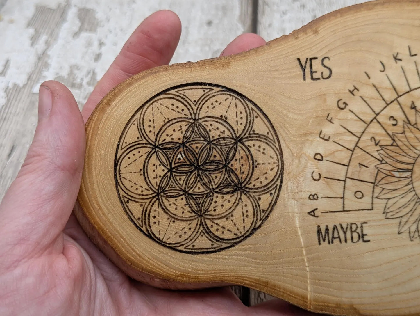 Ash wood laser printed pendulum dowsing board with sunflower detail.