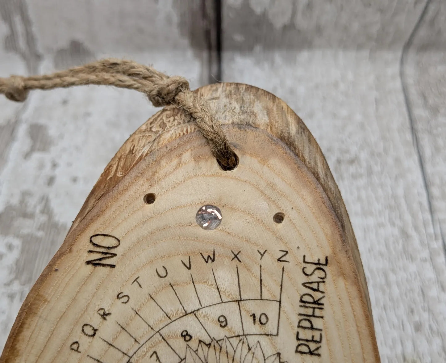 Ash wood laser printed pendulum dowsing board with sunflower detail.