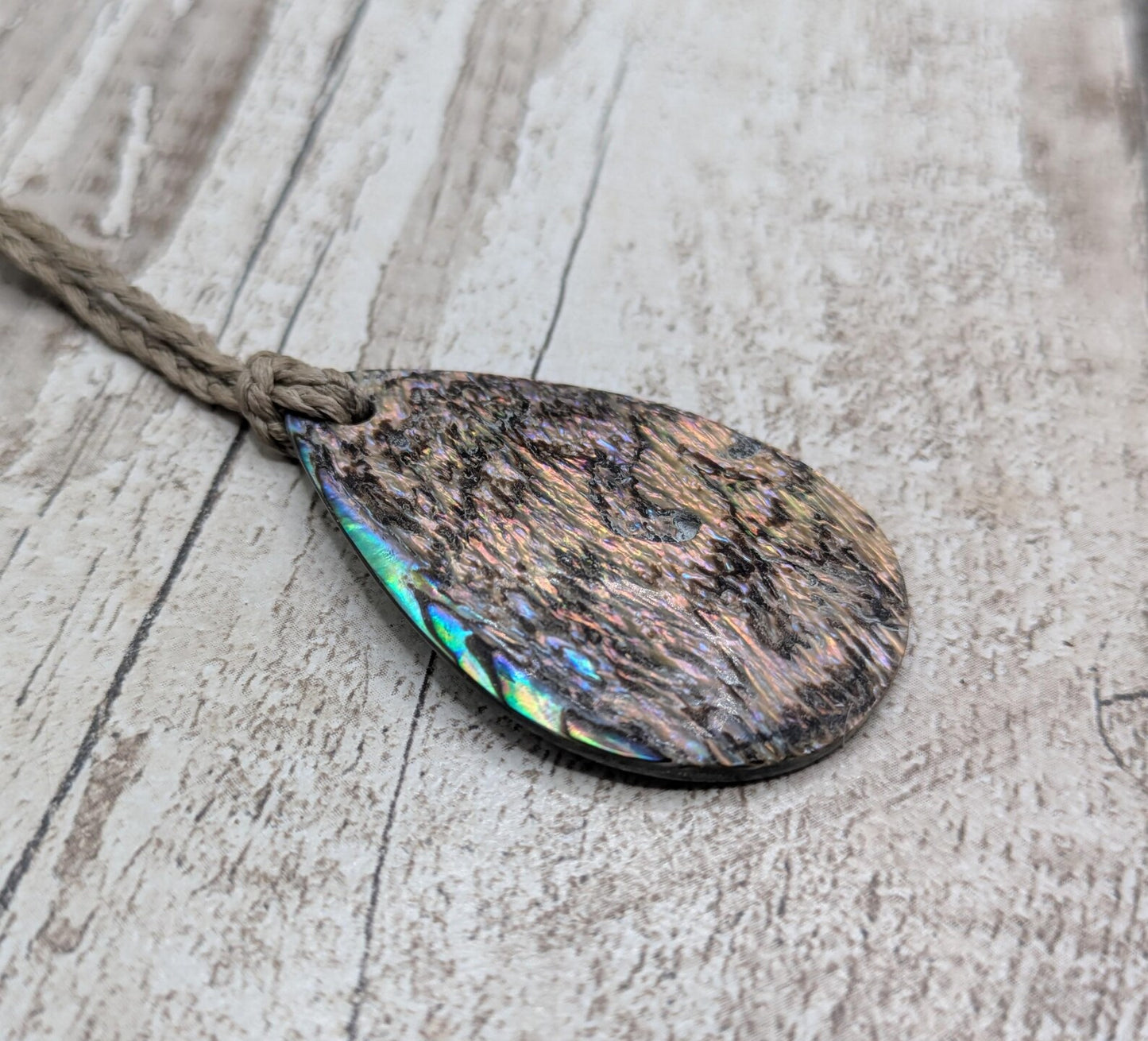 Carved NZ Pāua Shell Oval Pendant – Handcrafted Rainbow Abalone Jewel, Ocean-Inspired fashion, iridescent amulet.