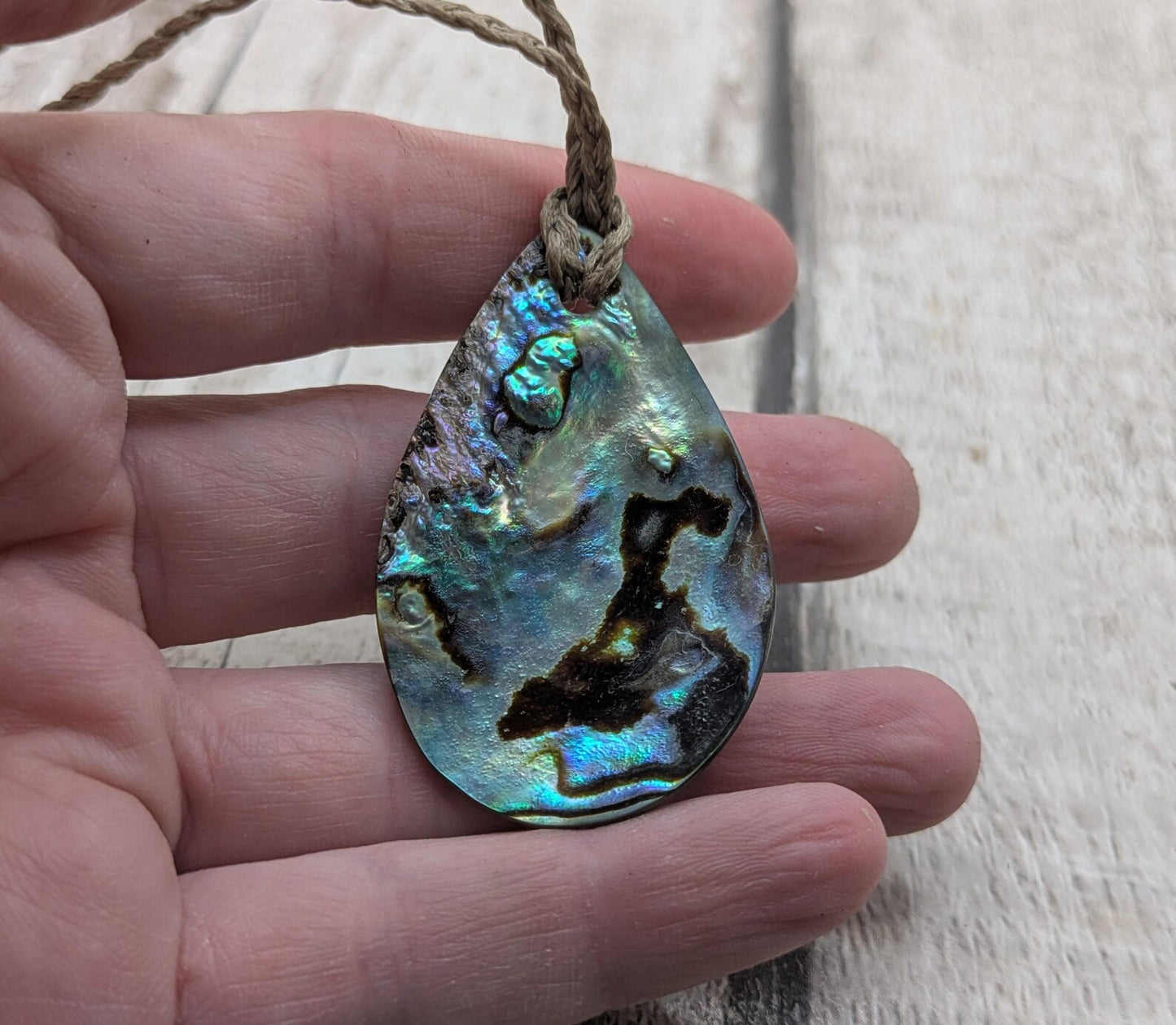 Carved NZ Pāua Shell Oval Pendant – Handcrafted Rainbow Abalone Jewel, Ocean-Inspired fashion, iridescent amulet.