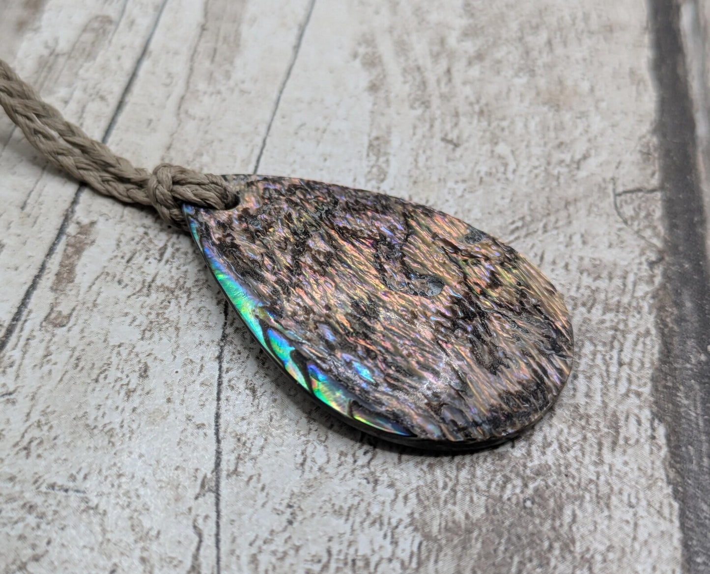 Carved NZ Pāua Shell Oval Pendant – Handcrafted Rainbow Abalone Jewel, Ocean-Inspired fashion, iridescent amulet.