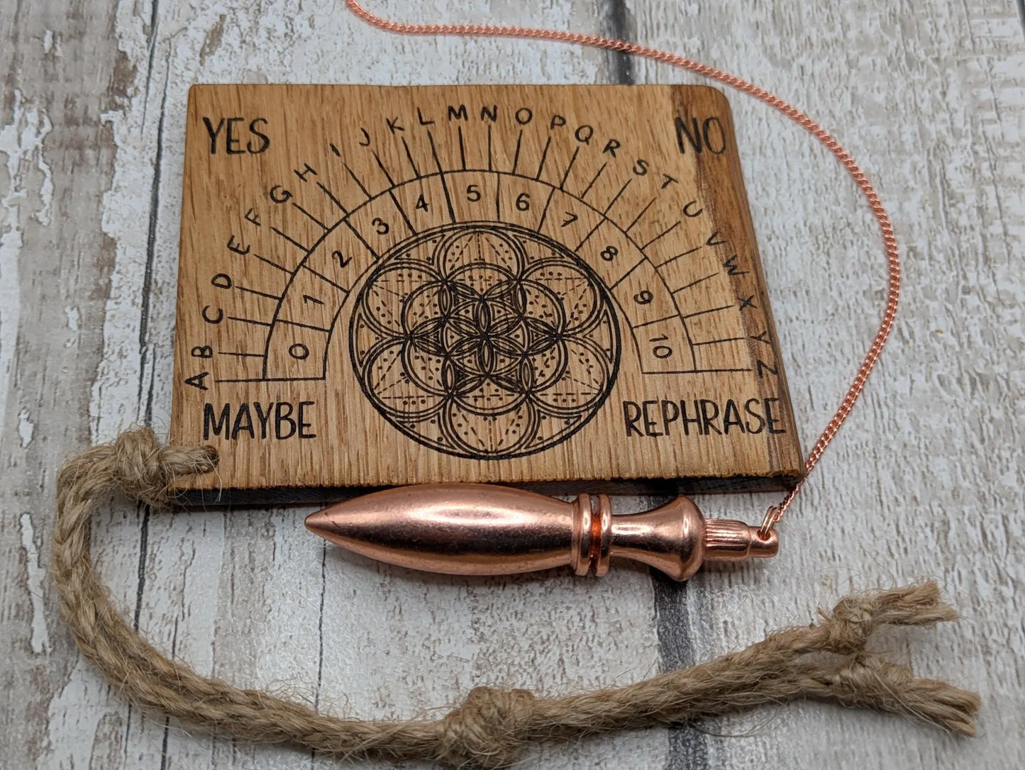 Oak wood travel sized pendulum board with geometric design.