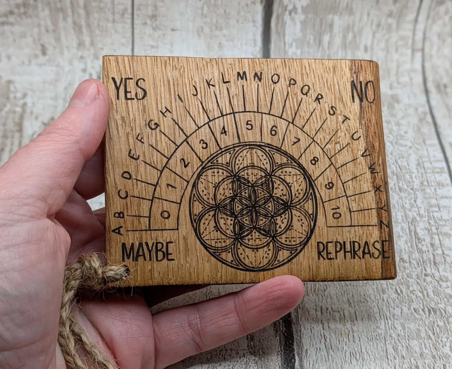 Oak wood travel sized pendulum board with geometric design.