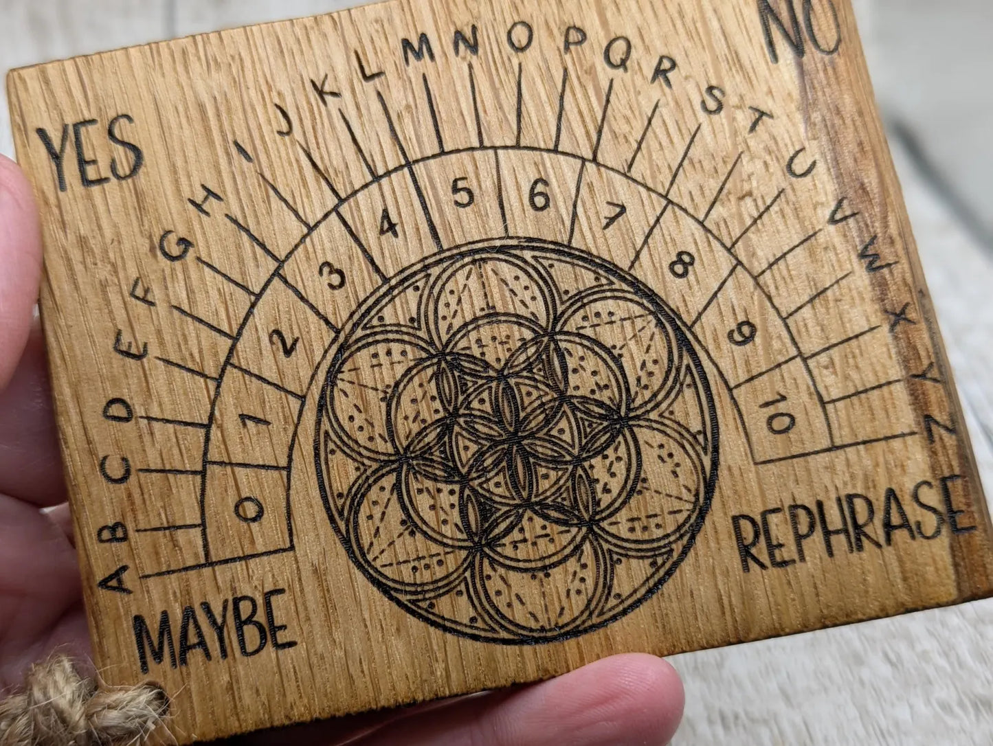 Oak wood travel sized pendulum board with geometric design.