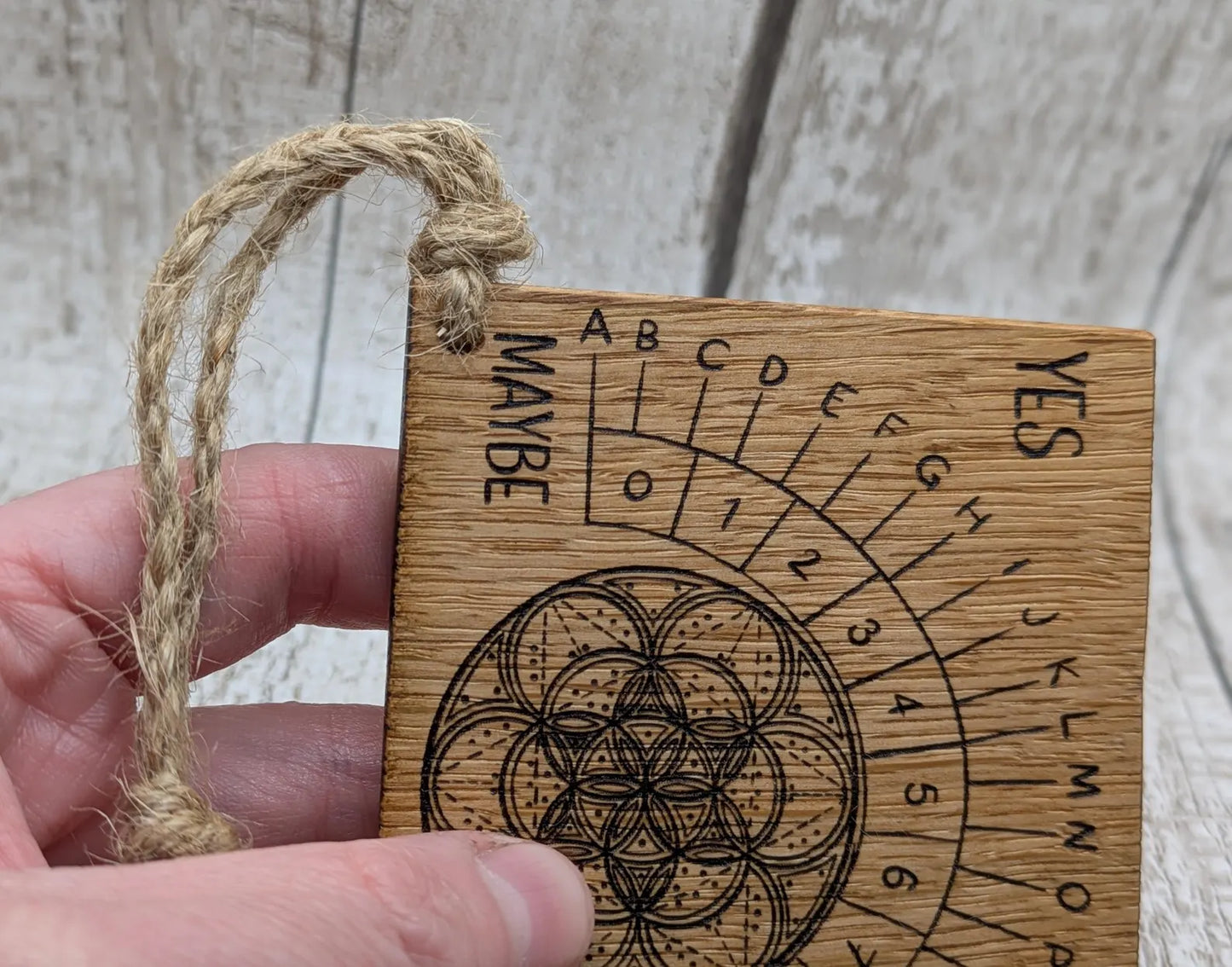 Oak wood travel sized pendulum board with geometric design.