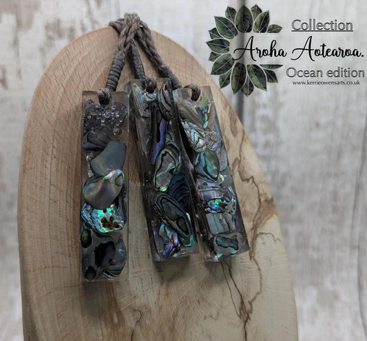 One New Zealand rainbow pāua chips in resin.