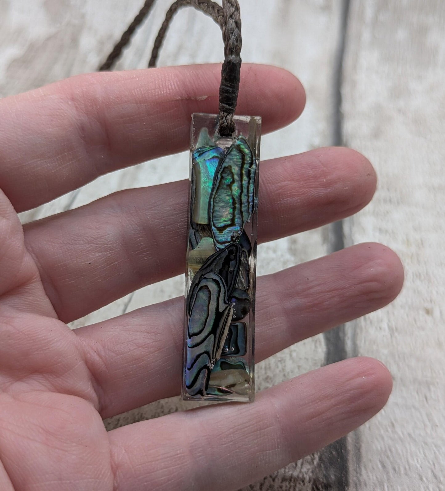 One New Zealand rainbow pāua chips in resin.