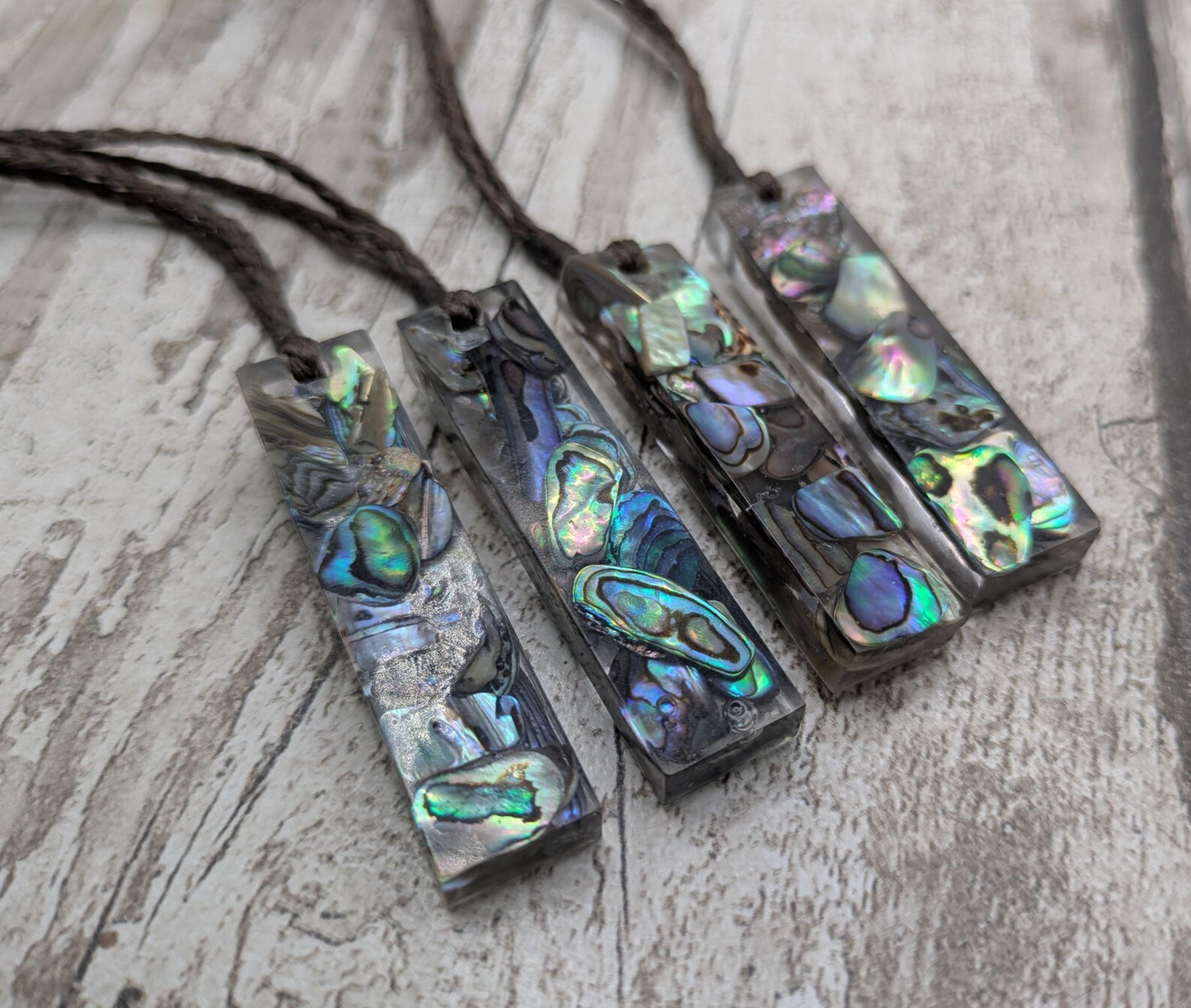 One New Zealand rainbow pāua chips in resin.