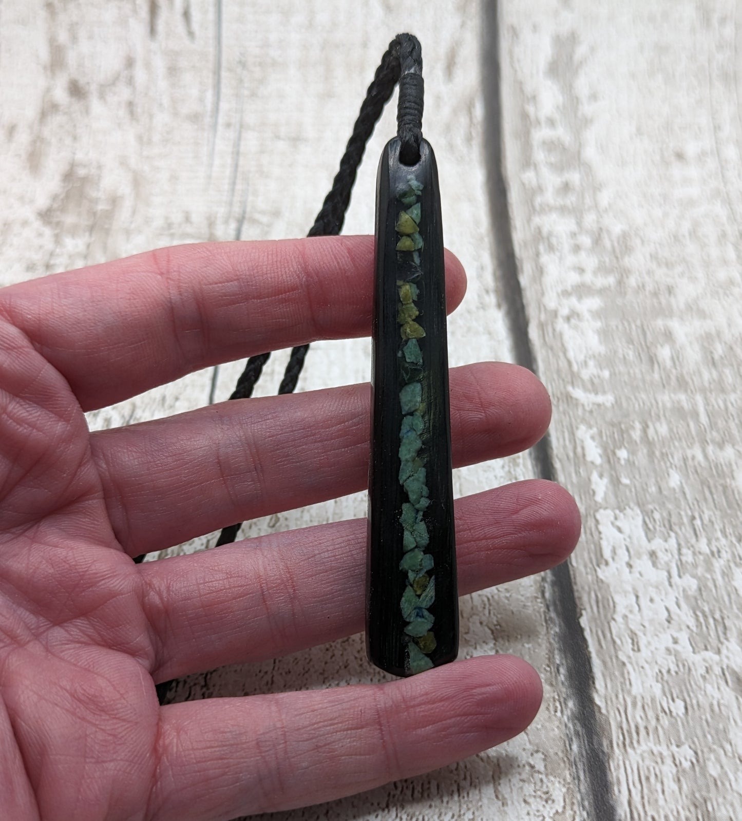 Fenland bog oak roimata with pounamu greenstone pendant.