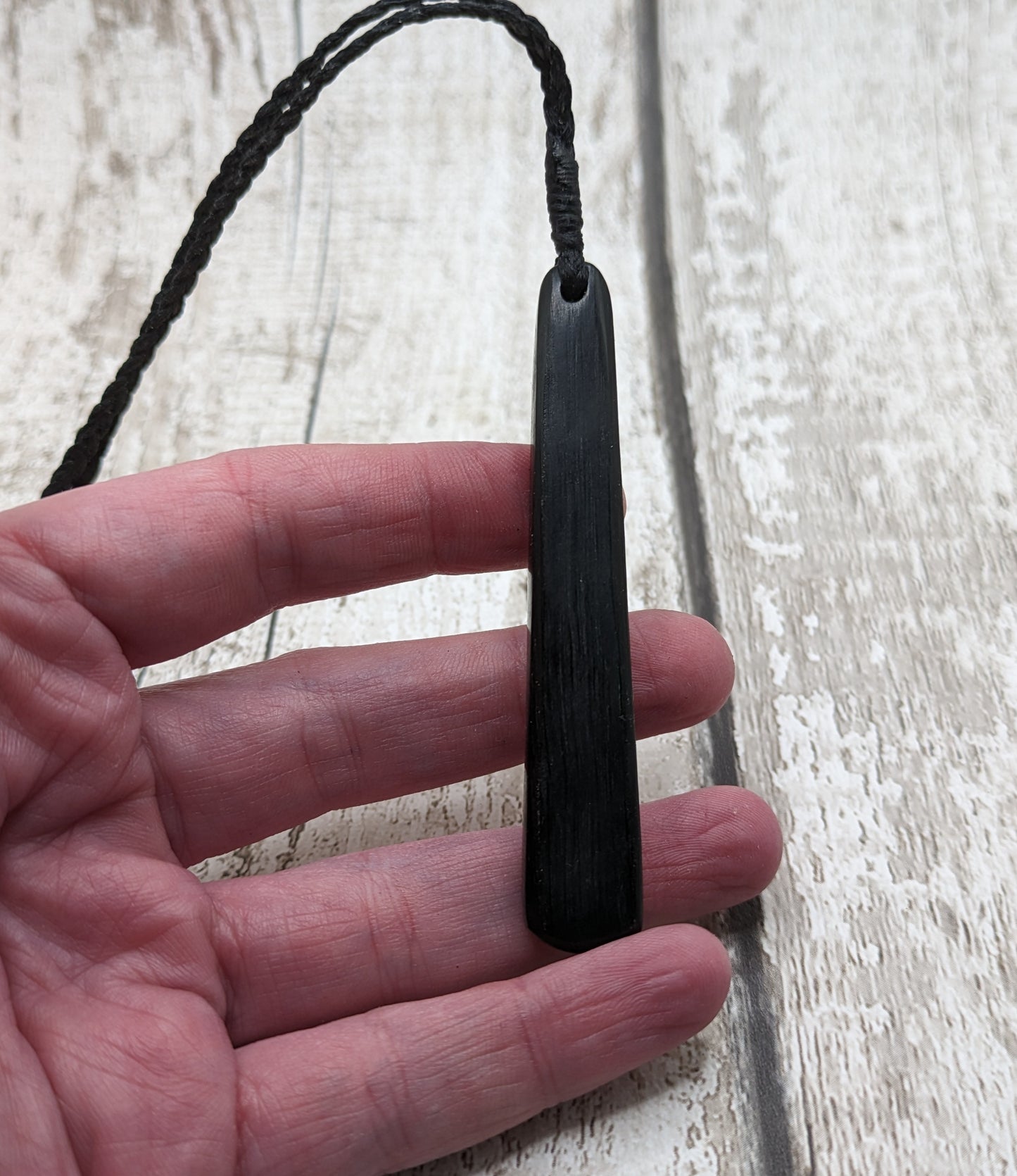 Fenland bog oak roimata with pounamu greenstone pendant.