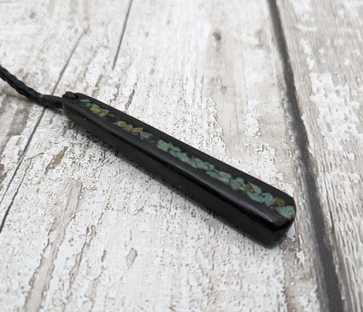 Fenland bog oak roimata with pounamu greenstone pendant.