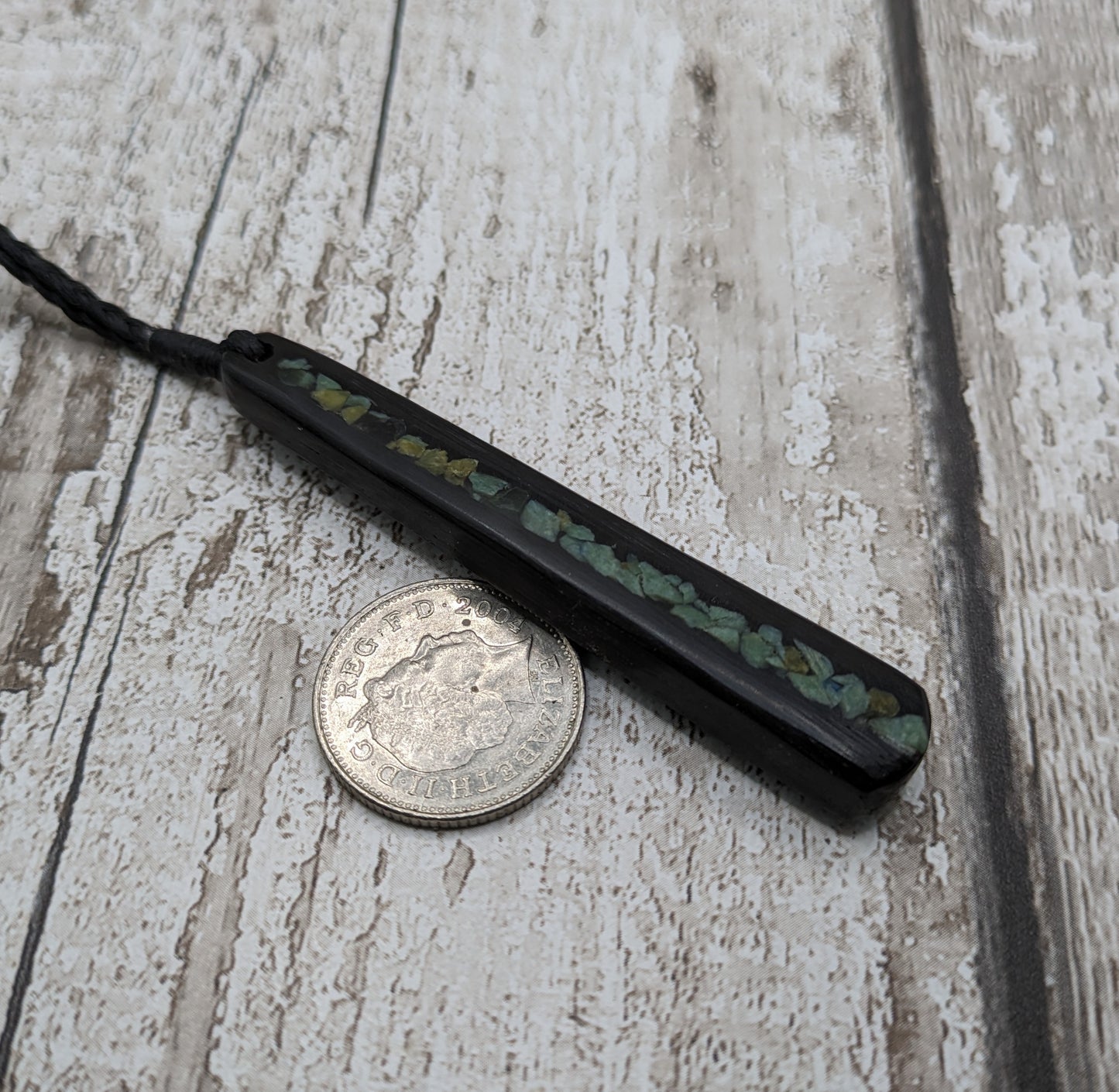 Fenland bog oak roimata with pounamu greenstone pendant.