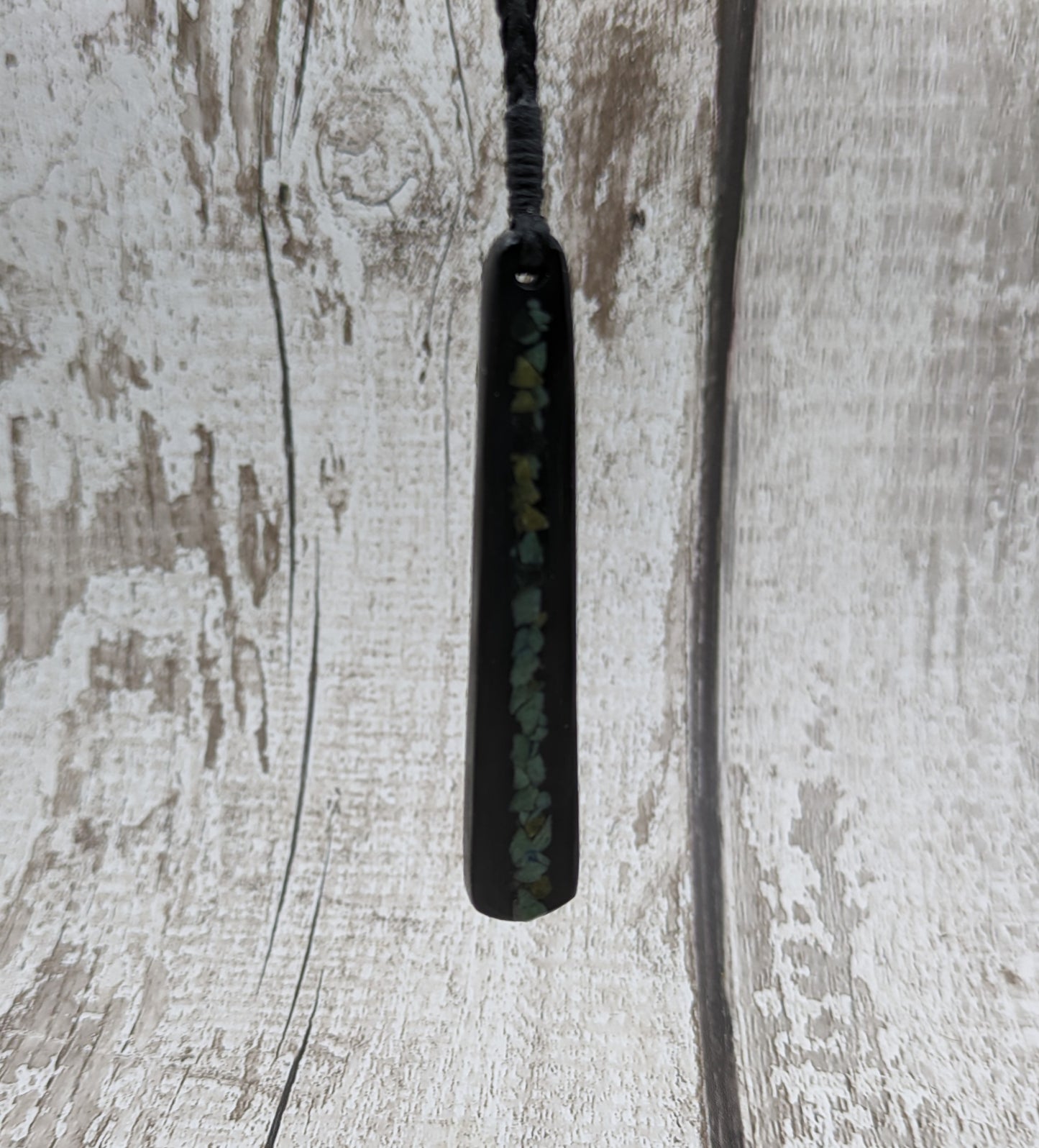 Fenland bog oak roimata with pounamu greenstone pendant.