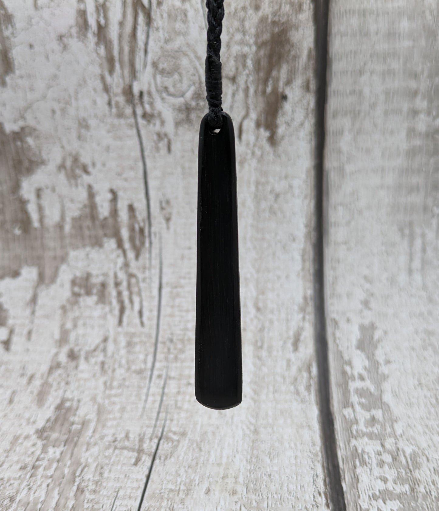 Fenland bog oak roimata with pounamu greenstone pendant.