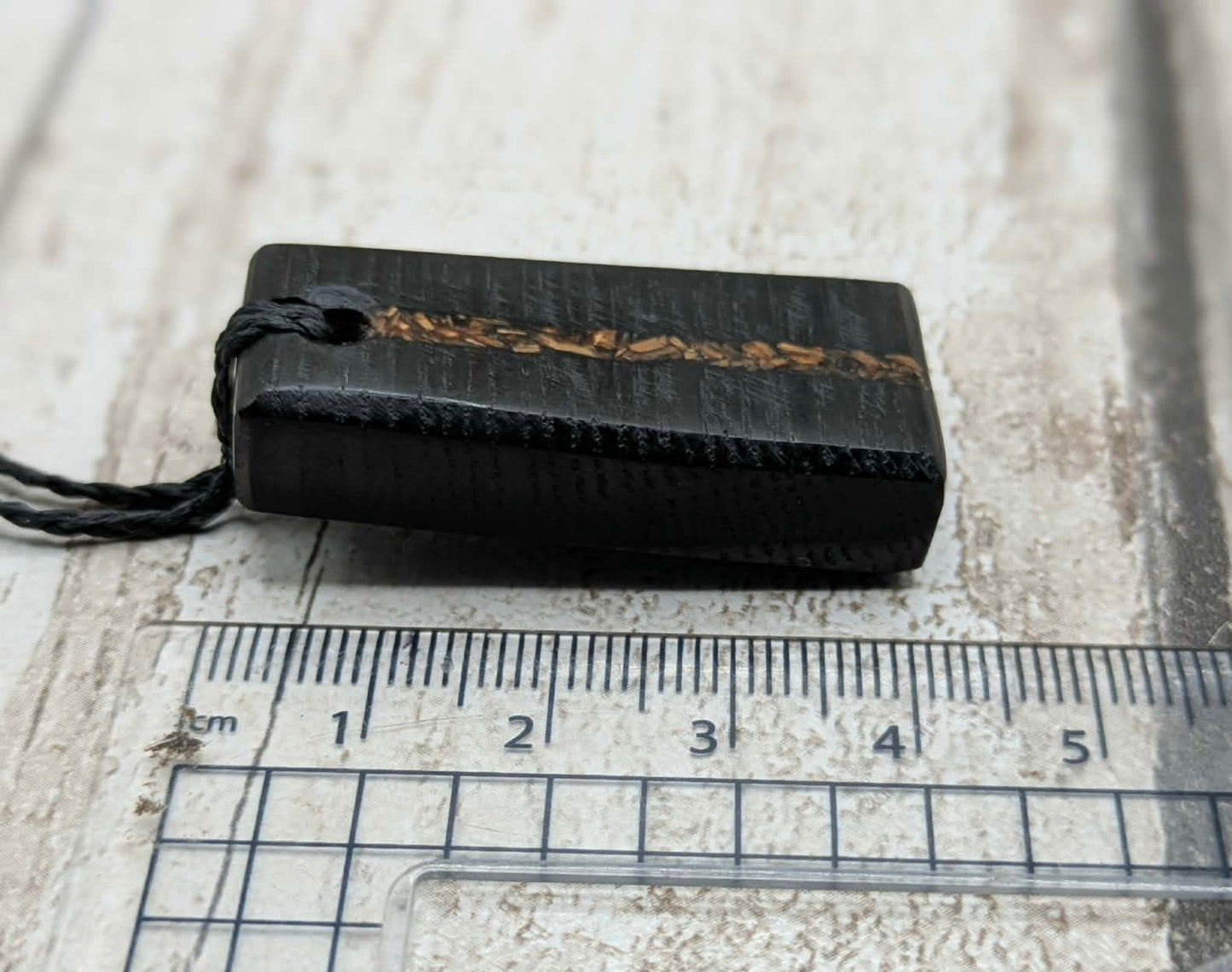 Fenland bog oak rectangular pendant with mammoth tooth inlay.