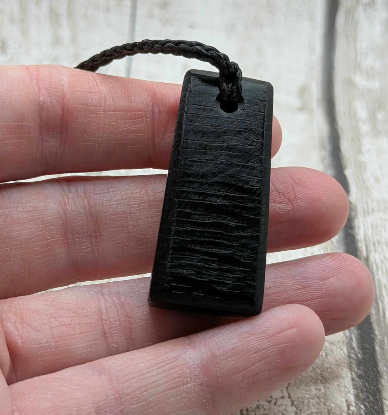 Fenland bog oak rectangular pendant with mammoth tooth inlay.