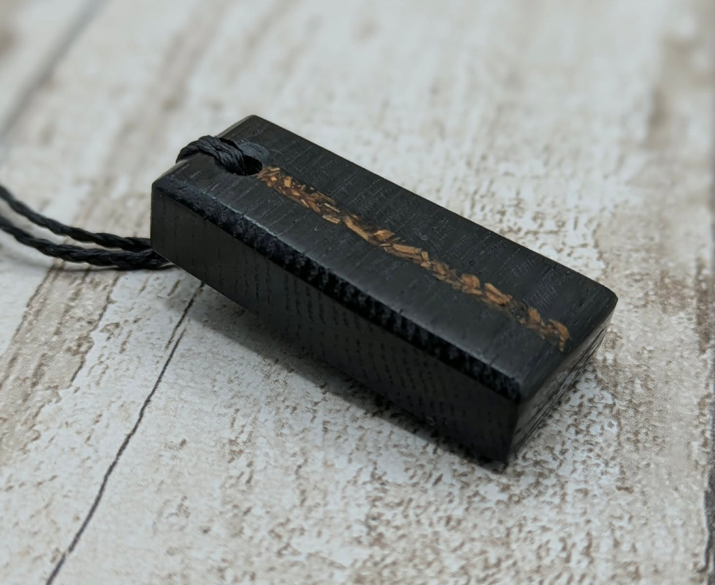 Fenland bog oak rectangular pendant with mammoth tooth inlay.