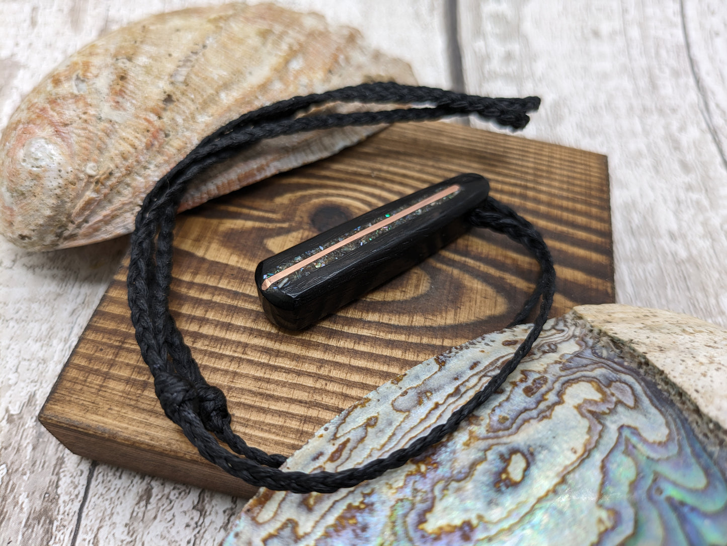 Fenland my bog oak roimata pendant with NZ pāua shell and copper wire.