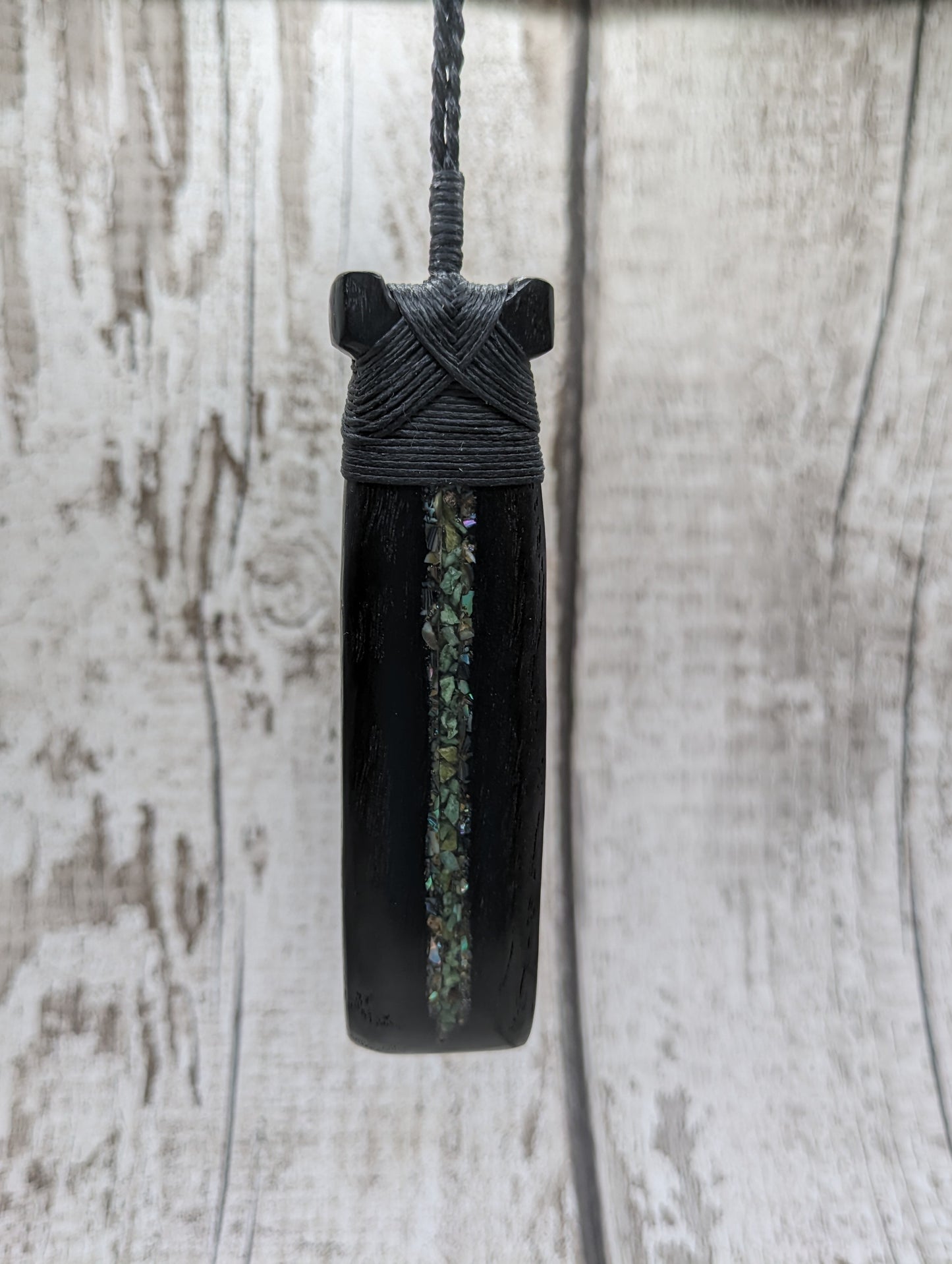 Fenland bog oak hei toki adze with pāua and pounamu.