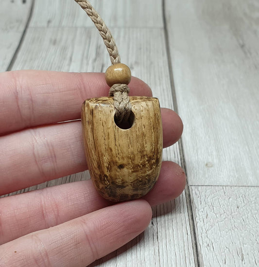 Simple oak wood carved unisex pendant.