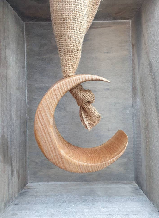 Wooden hanging moon ornament with hessian ribbon.