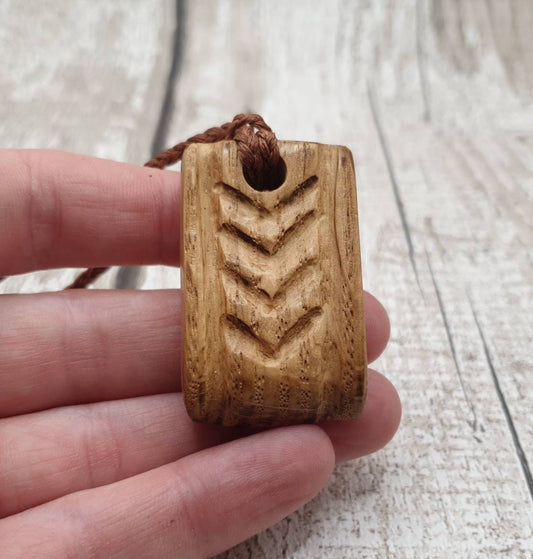 Carved oak tribal unisex pendant.