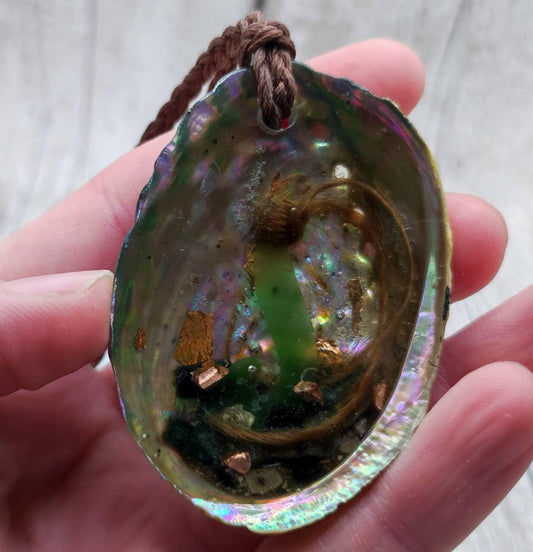 New Zealand pounamu greenstone nephrite jade hei matau, fish hook in paua shell.