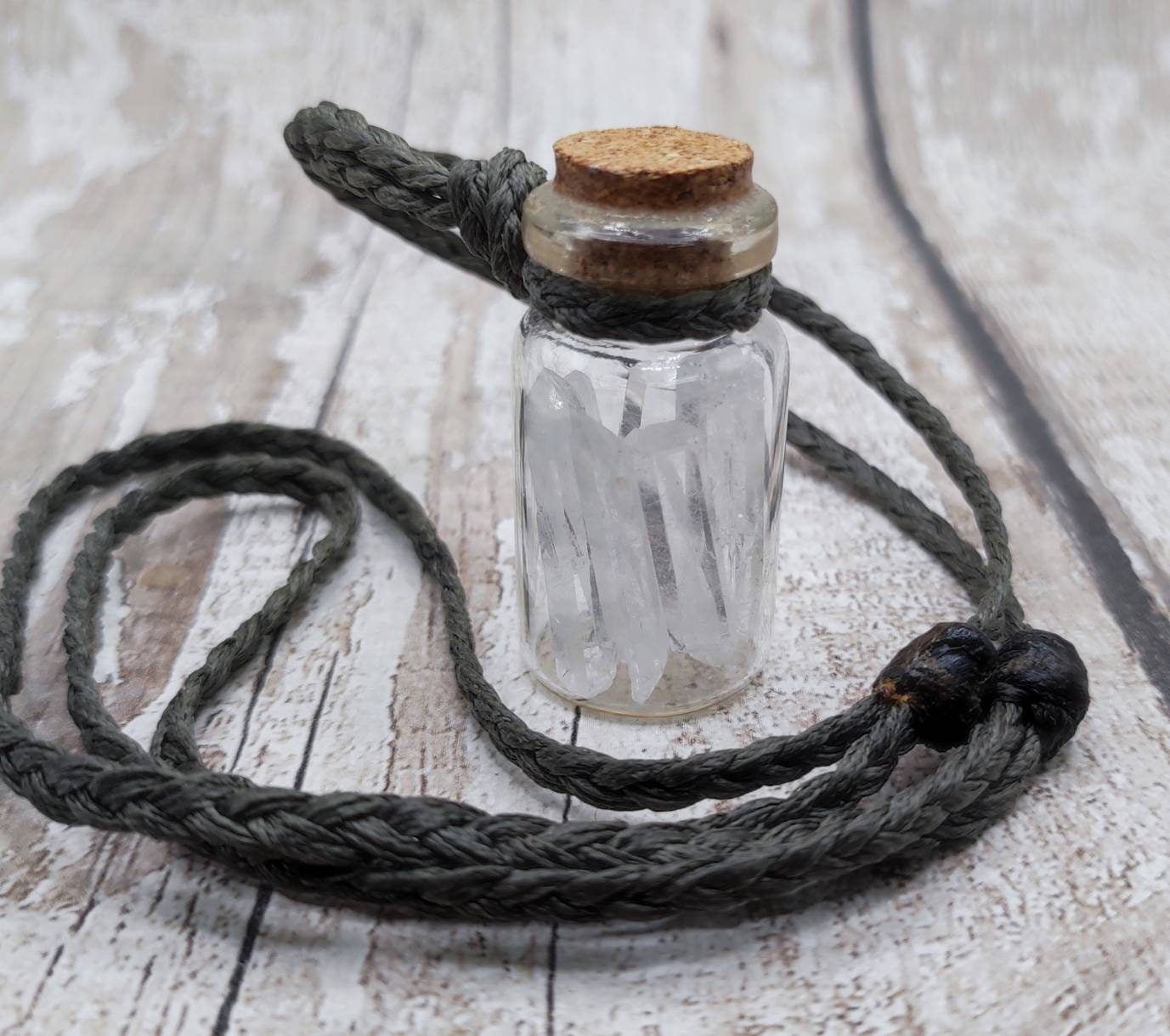 Quartz filled glass bottle pendant.