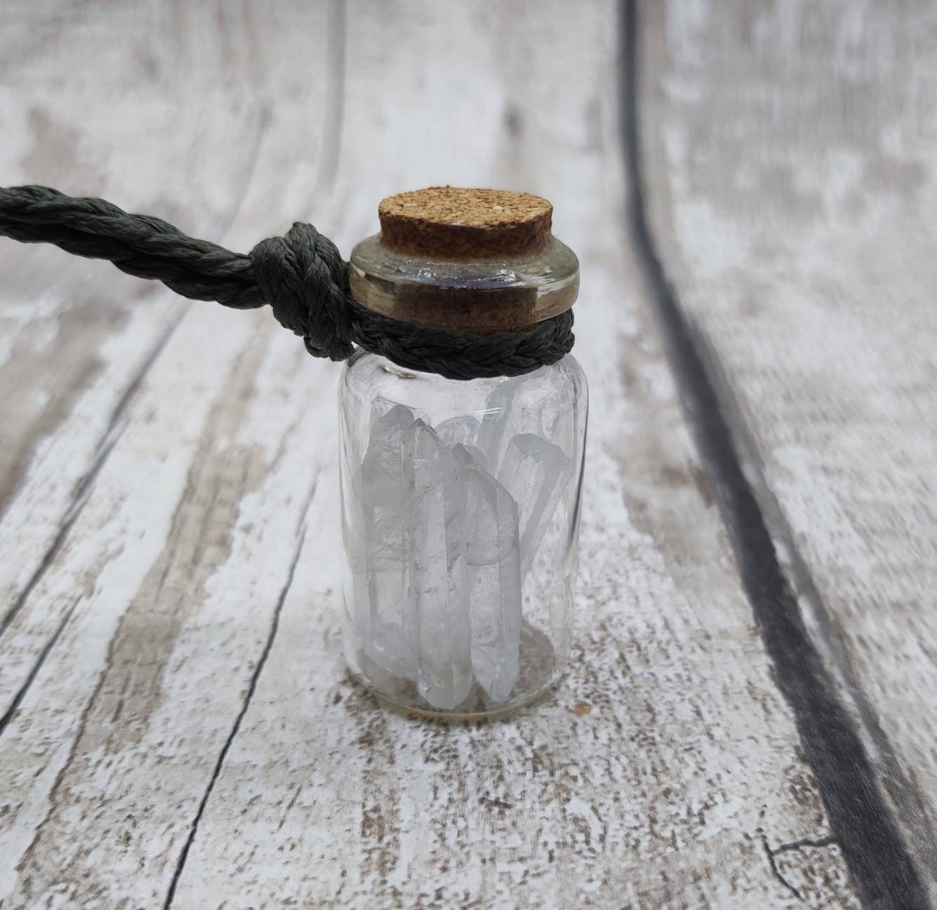 Quartz filled glass bottle pendant.