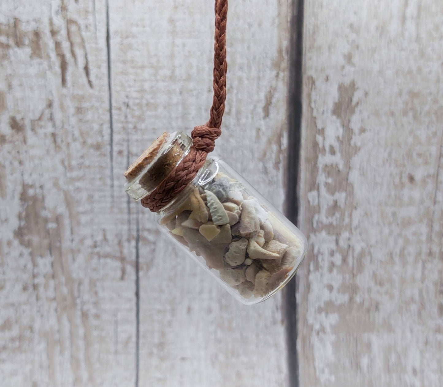 Fossilised sharks teeth glass bottle pendant.