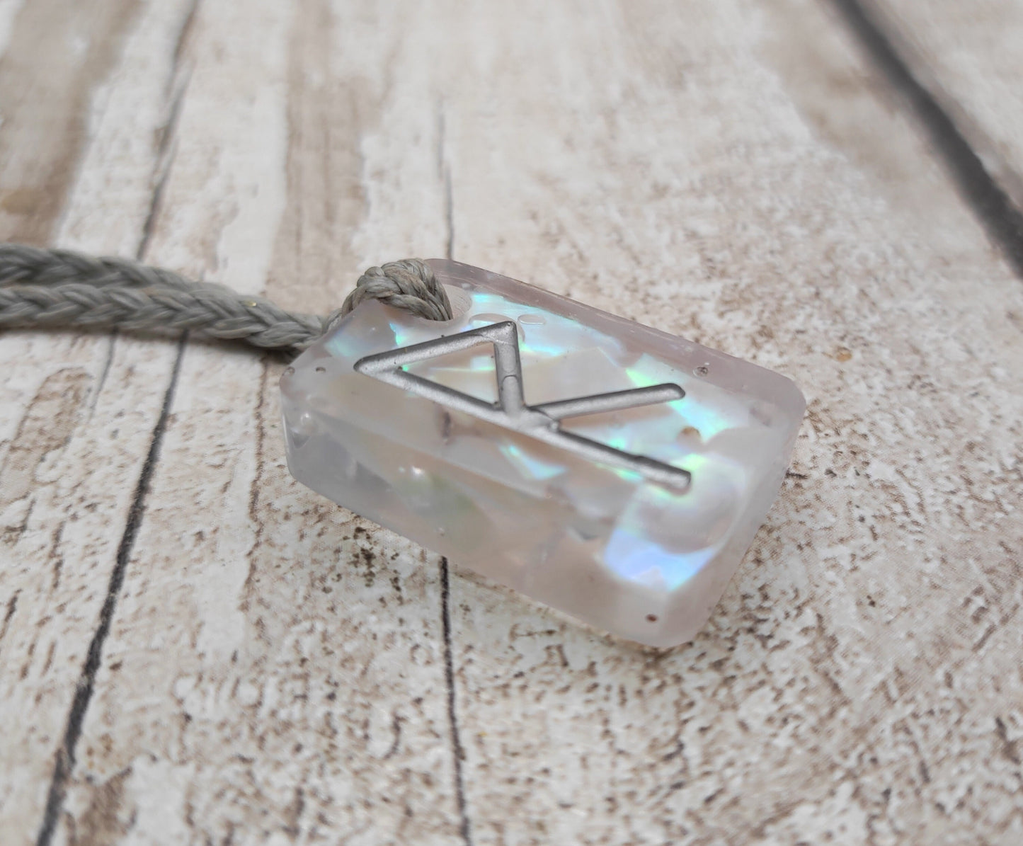 Raido rune pendant with UV resin and mussel shell.