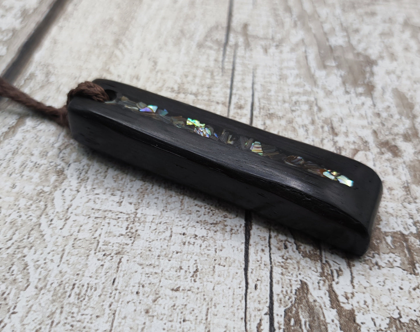 Bog oak and NZ rainbow pāua shell toki pendant.