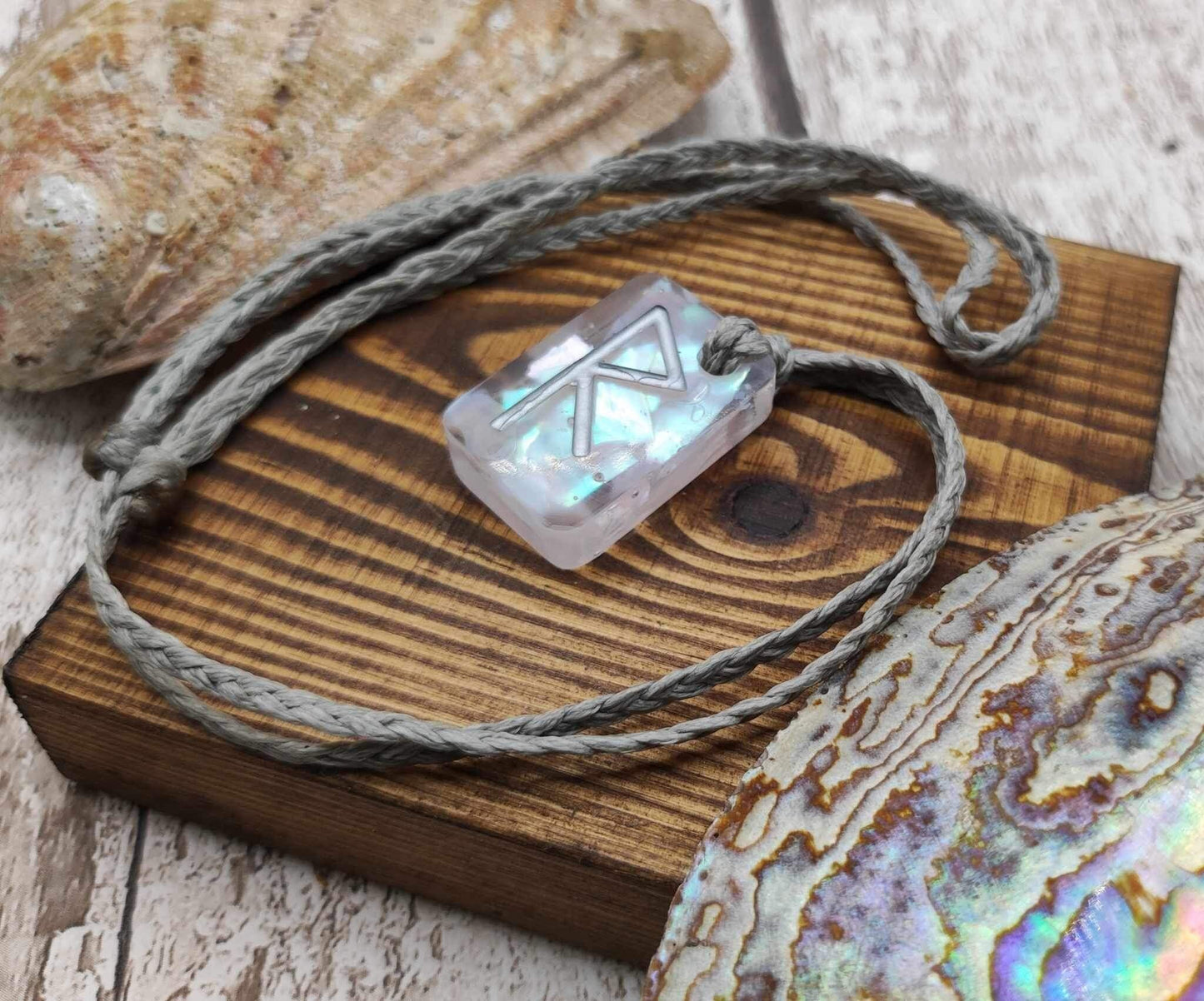 Raido rune pendant with UV resin and mussel shell.